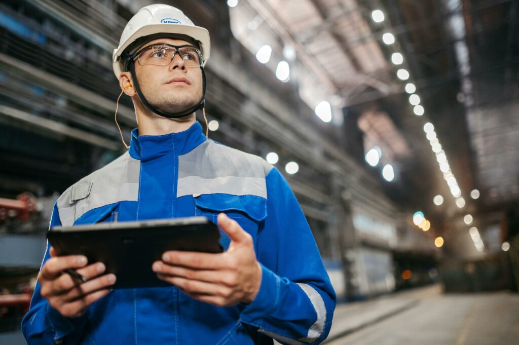 Manufacturing engineer analyzing real-time data on a tablet, representing industry news and insights