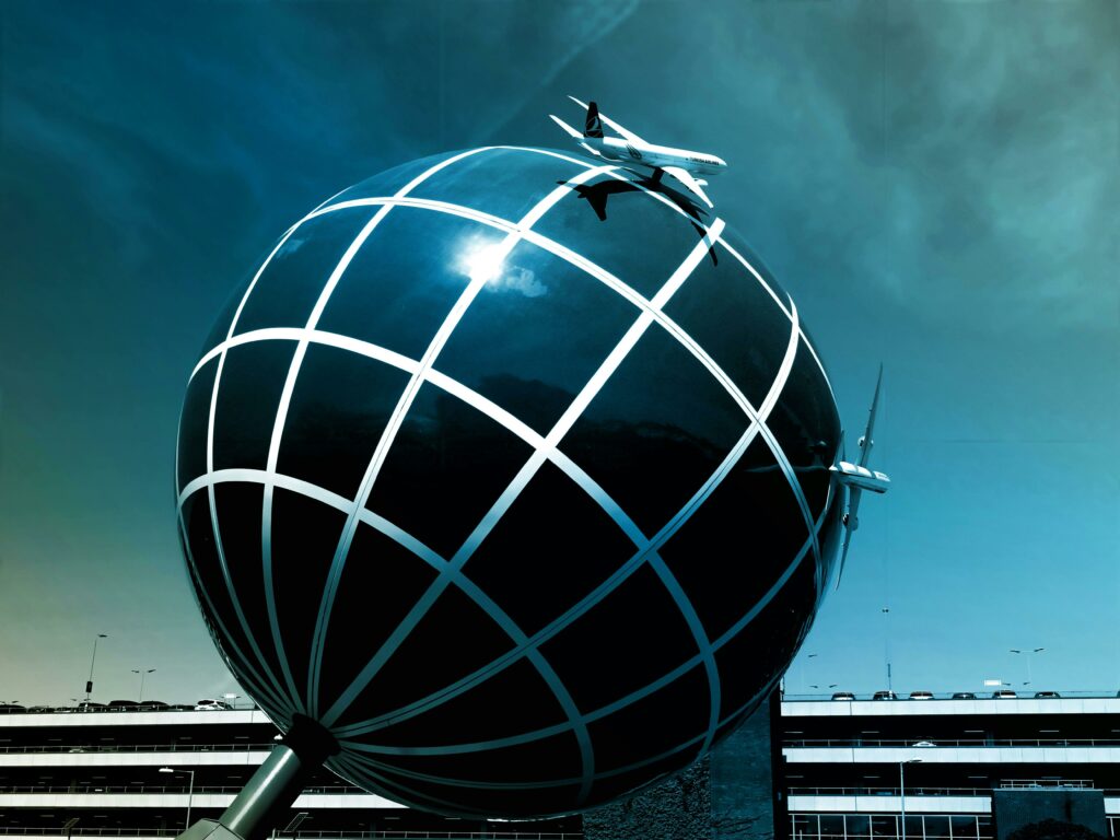 Illuminated globe sculpture with airplanes flying overhead, representing global presence