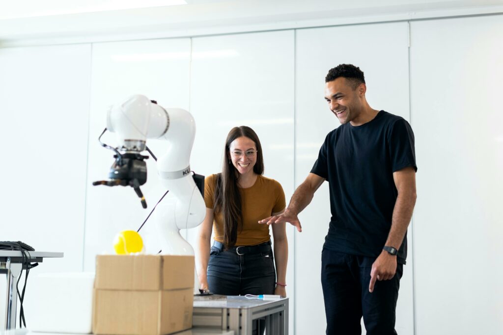Engineers collaborating with a collaborative robot (cobot) in a manufacturing lab, representing Chronos's global footprint across Automotive, Aerospace, Industrial, and Consumer goods sectors