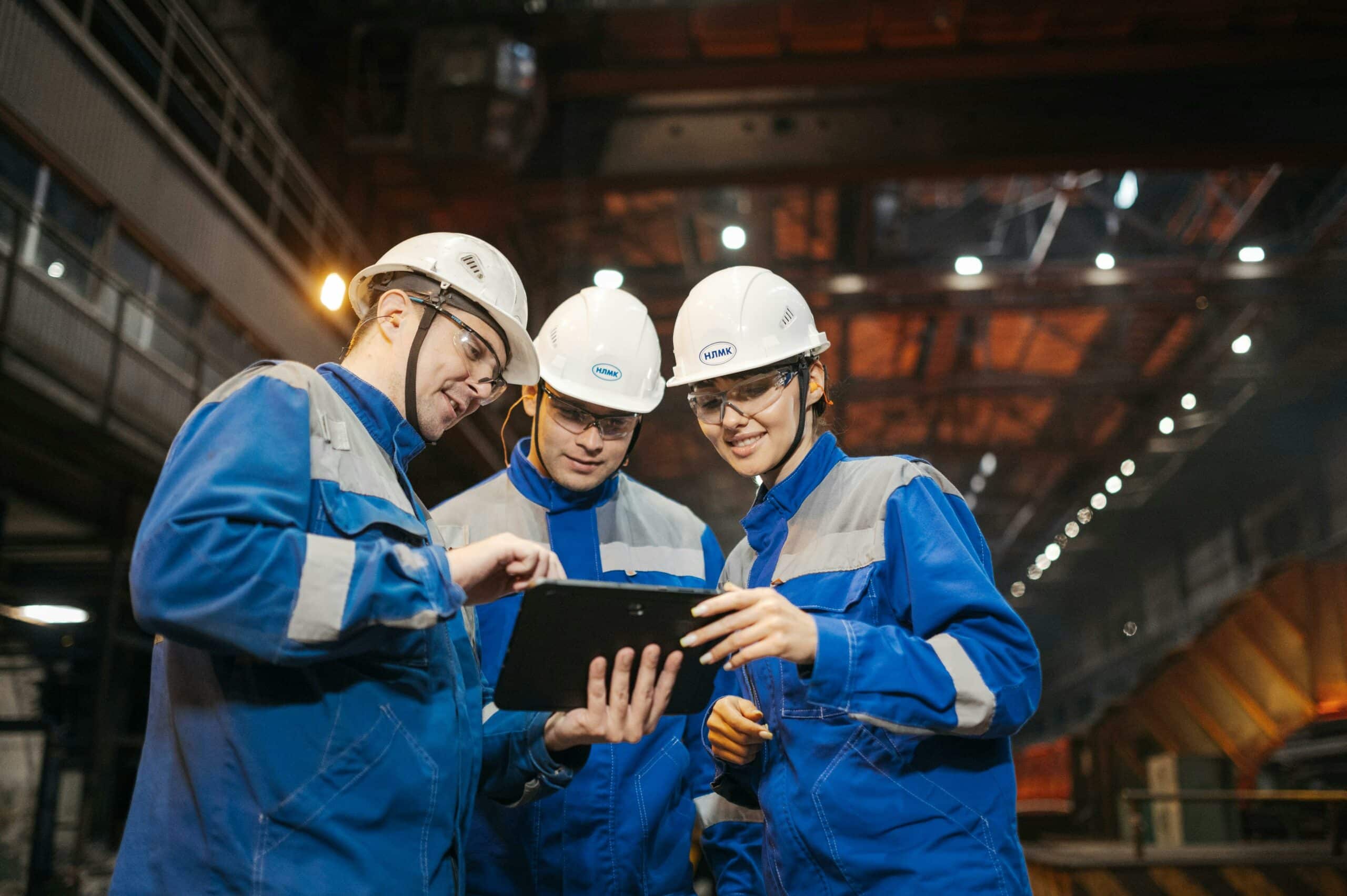 Manufacturing engineers reviewing plant data on a tablet during a shift